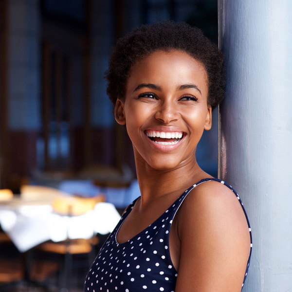 Young Woman Laughing While Leaning Against the Wall