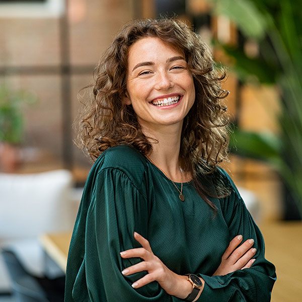 Woman in Green Shirt Smiling Indoors